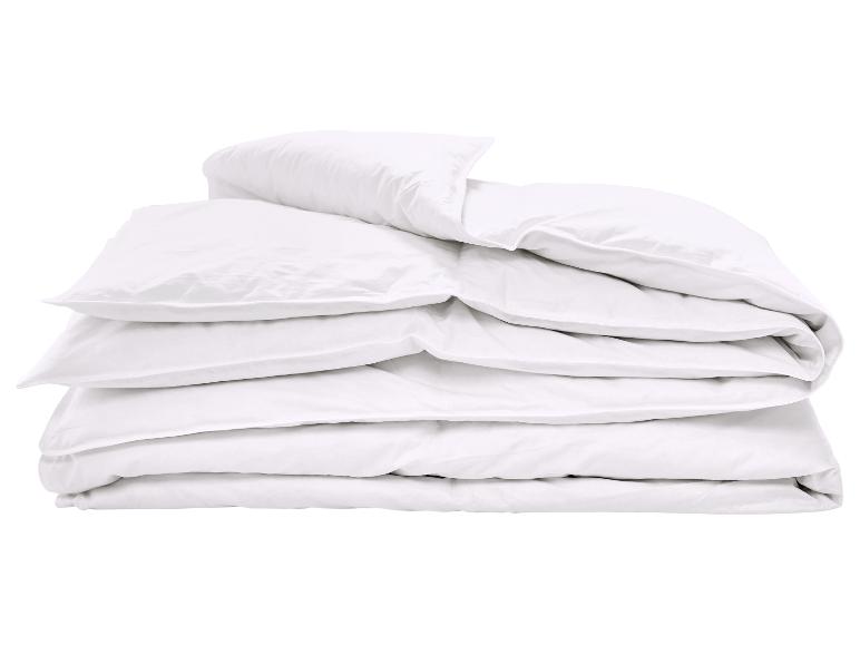 Stapel weißer, weicher Kissen und Bettdecken