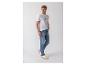 Mann in weißem T-Shirt und blauen Jeans, blickt nach links, mit weißen Sneakern.