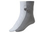 Zwei Paar gestrickte Socken mit Bommel, eine weiße und eine graue.