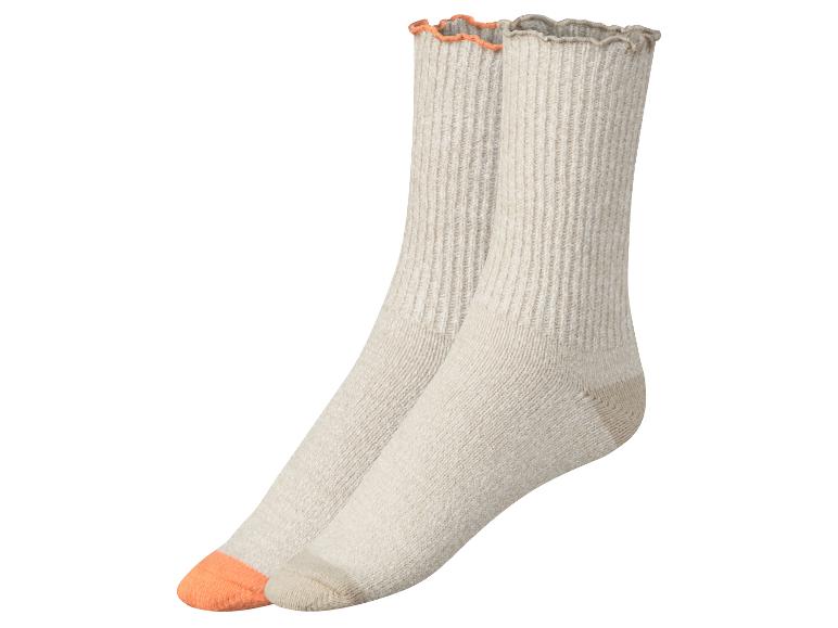 Zwei Paar beige Socken mit orangefarbenem Rand.