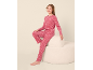 Mädchen in rosa gepunktetem Pyjama auf einem weißen Hocker sitzend