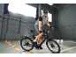 Mann auf einem E-Bike mit Helm und Brille, fährt in Innenräumen.