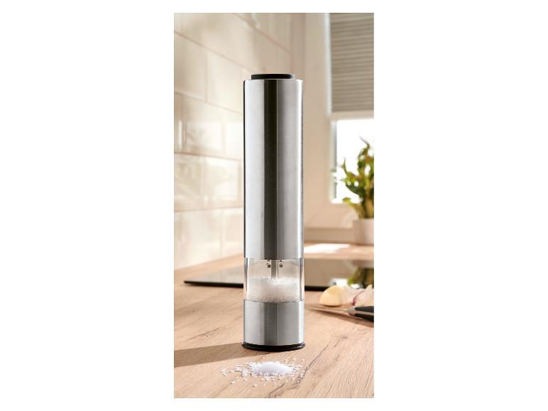 Elektrische Salzmühle aus Edelstahl auf einer hölzernen Küchenarbeitsplatte.