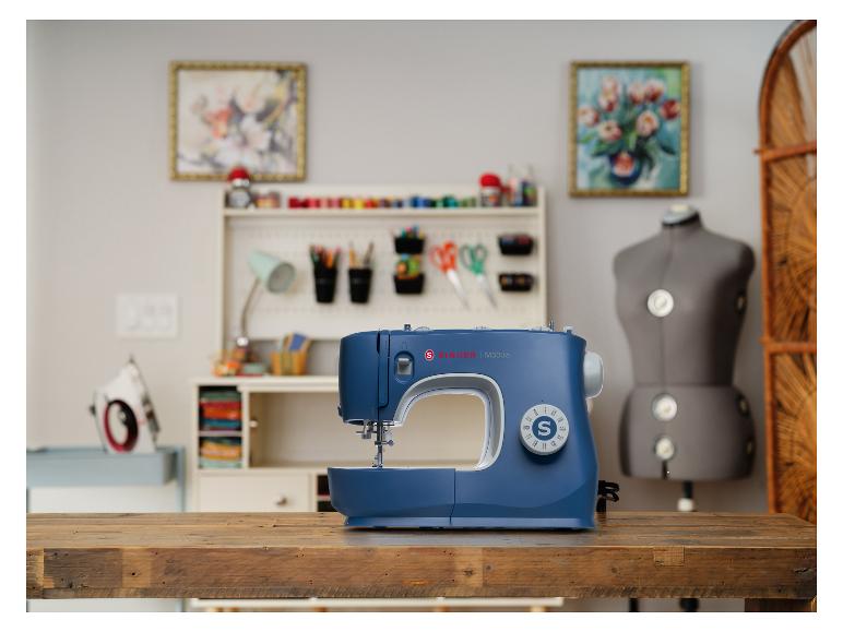 Singer M3335 Nähmaschine auf einem Holztisch in einem Bastelzimmer.