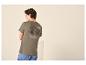Mann von hinten in einem khakifarbenen T-Shirt mit Bergmotiv und Text über die Natur.