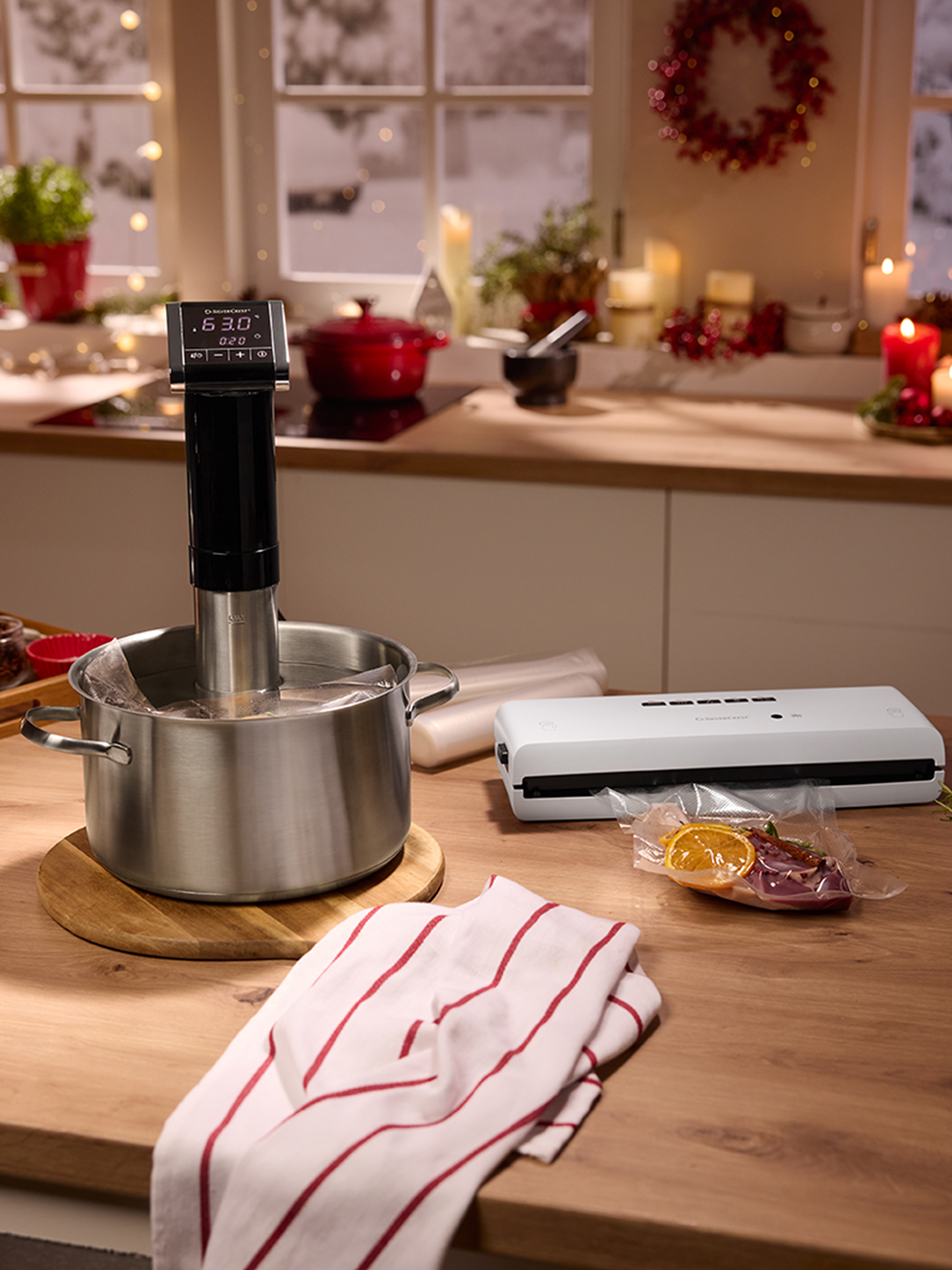 Sous-Vide-Garer und Vakuumiergerät auf einer festlich dekorierten Küchenarbeitsplatte.