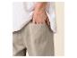 Mann in gestreiftem Hemd und Leinenhose mit der Hand in der Tasche.