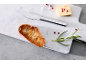 Marmorbrett mit geröstetem Brot, Butter, Kräutern und einem Buttermesser.