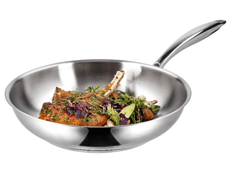 Edelstahl-Bratpfanne mit Lammkoteletts und Kräutern.