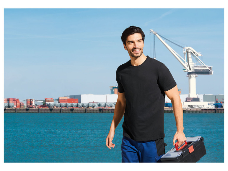 Ein Mann mit einer Werkzeugkiste in einem Hafen