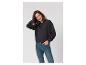 Frau in schwarzem Sweatshirt und Jeans, lächelnd.