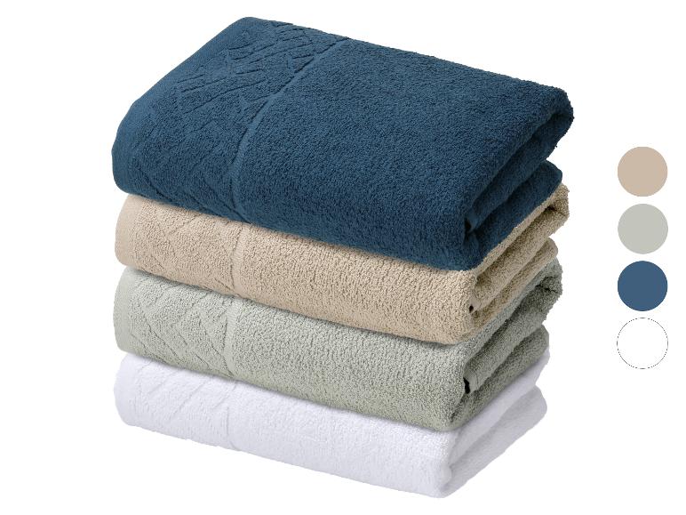 Stapel von vier Handtüchern in Blau, Beige, Grün und Weiß.