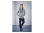 Mann trägt einen grauen Kapuzenpullover und blaue Hose.