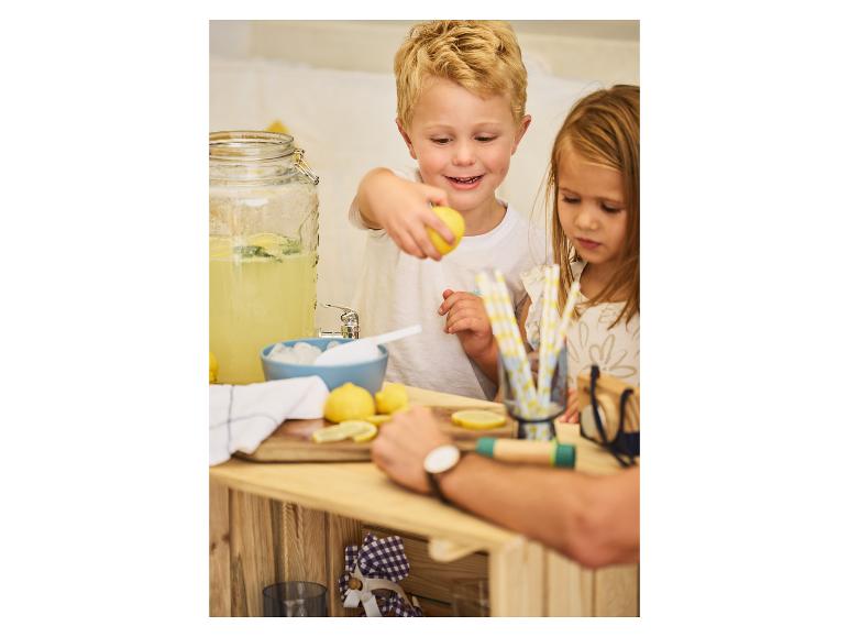Kinder bereiten Limonade mit Zitronen und bunten Strohhalmen zu.