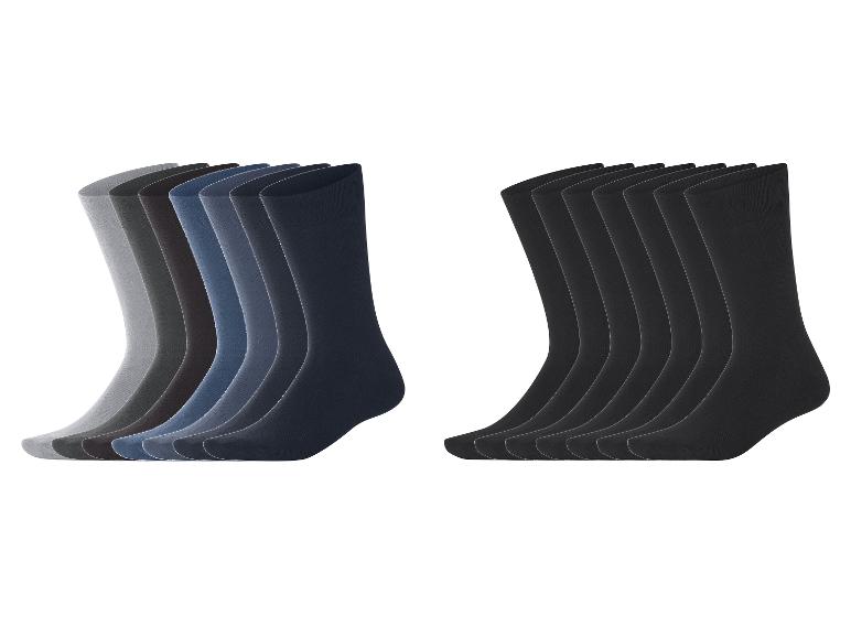 Zwei Packungen Herrensocken: eine mit Grau- und Blautönen, die andere mit schwarzen Socken.