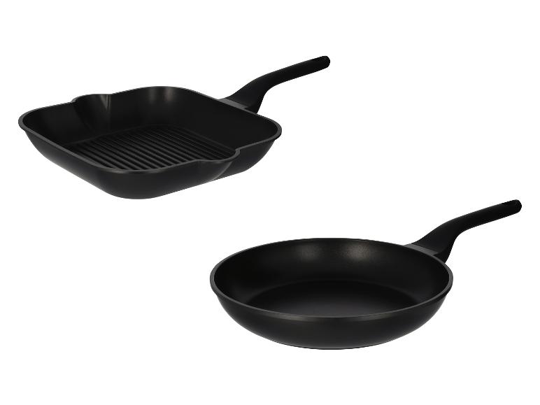 Zwei schwarze Pfannen, eine Grillpfanne und eine Bratpfanne, auf weißem Hintergrund.