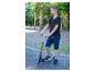 Junge mit schwarzem und grünem Roller auf einem Spielplatz.