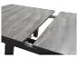 Ausziehbarer Tisch in Grau mit Holzoptik.