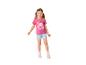 Mädchen in einem pinken bedruckten T-Shirt und kurzen Jeansshorts