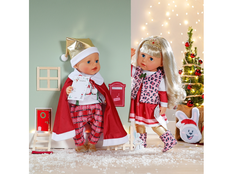 Zwei Weihnachtspuppen in festlicher Kleidung in einer verspielten Winterlandschaft.