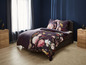 Bettwäsche mit Blumenmuster in einem dunkelblauen Schlafzimmer.