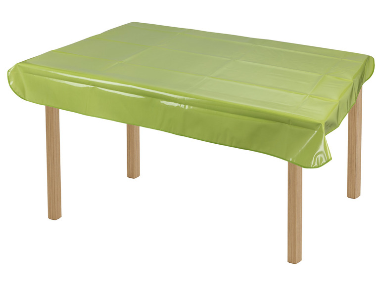 Ein grüner Plastiktischdecke auf einem Holztisch.
