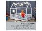 Weißes Hausbett für Kinder mit spielendem Kind, Text „HAUSDESIGN“.