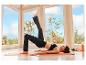 Eine Frau in schwarzen CRIVIT Funktionstights macht Yoga auf einer Matte.