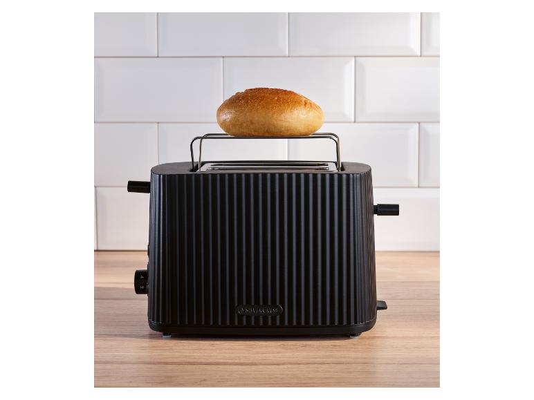 Schwarzer SilverCrest Toaster mit Brötchen in einer Küche mit weißer Fliesenwand und Holzarbeitsplatte