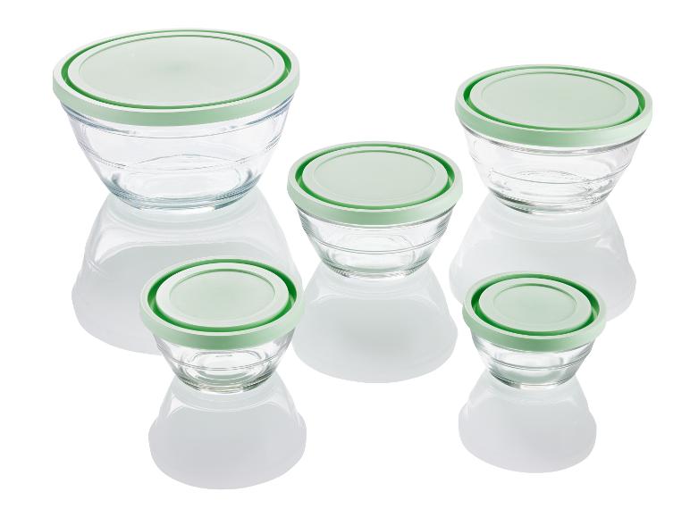 Vier Glasschalen mit grünen Deckeln.