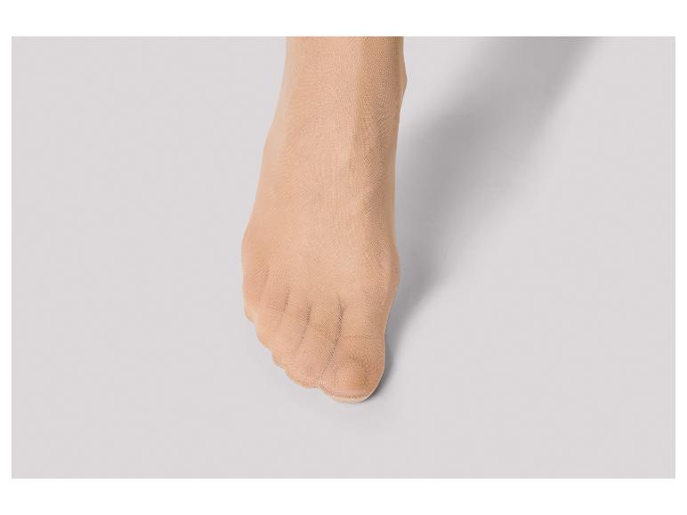 Nahaufnahme eines Fußes in hautfarbenen Strumpfhosen.