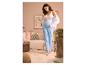 Schwangere Frau in ESMARA® Musselin-Umstandshose und weißem Top, hält ihren Bauch in einem gemütlichen Raum.