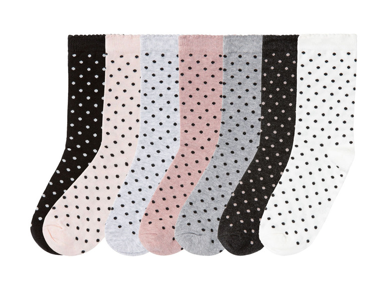 Sechs Paar weiße Socken mit schwarzen Punkten.