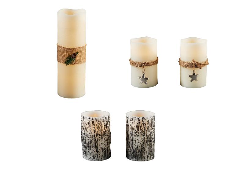 Verschiedene LED-Kerzen, darunter eine hohe mit Juteschnur und Tannenzapfen, zwei kleinere mit Sternanhänger und zwei mit Rindenstruktur.