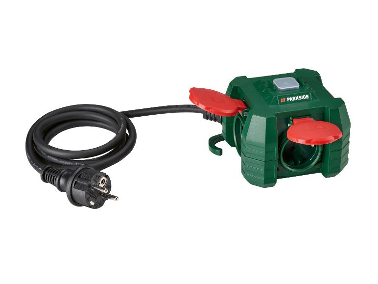 Grüne Dreifachsteckdose mit schwarzem Kabel und Stecker.