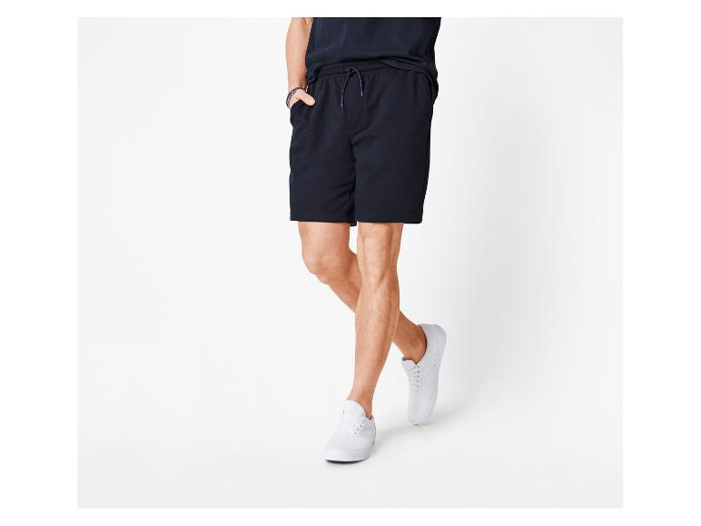 Schwarze Shorts und weiße Sneaker für Herren.