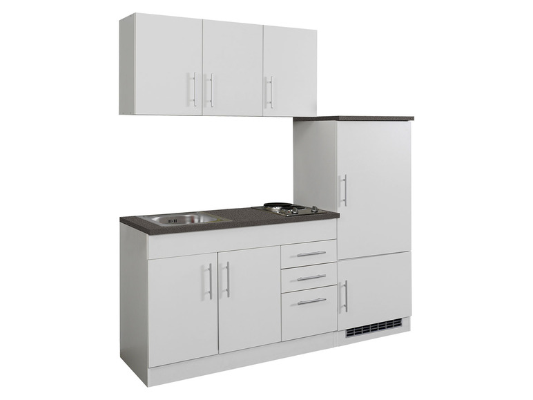 Eine weiße Küche mit Spüle, Kochfeld und Kühlschrank