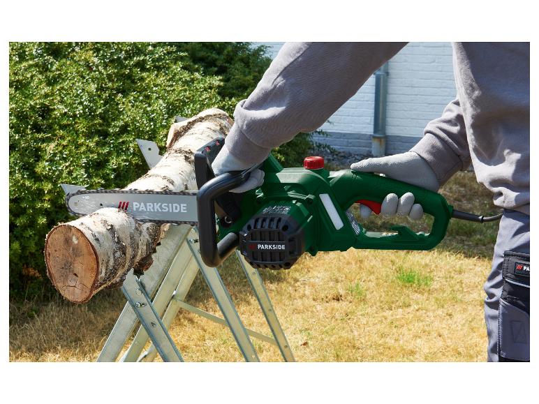 Person schneidet einen Baumstamm mit einer grünen Parkside Elektrokettensäge auf einem Sägebock.