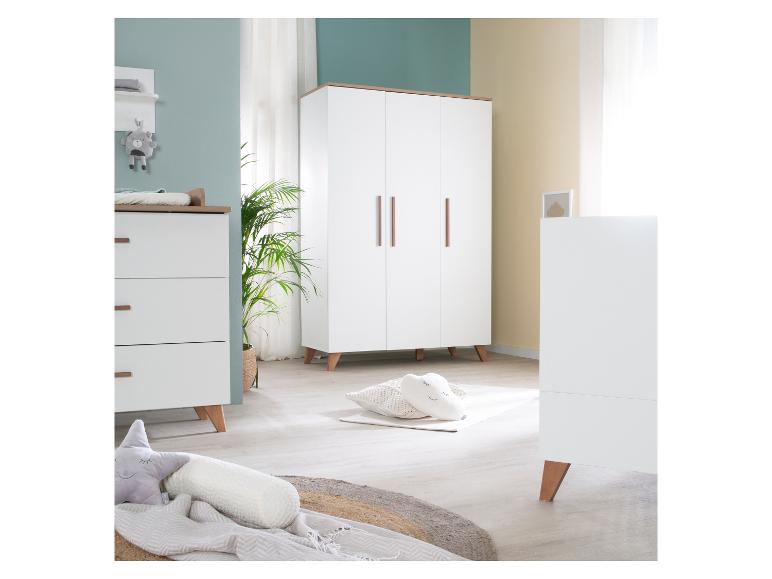 Ein modernes Kinderzimmer mit weißen und Holzmöbeln, darunter eine Kommode, ein Kleiderschrank und ein Babybett.