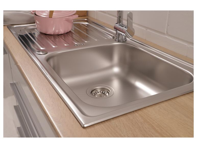 Edelstahlspüle mit einem rosa Topf auf einer Holzarbeitsplatte.