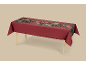 Rote Tischdecke mit festlichem Blumen- und Beerenmuster, über einem Holztisch drapiert.