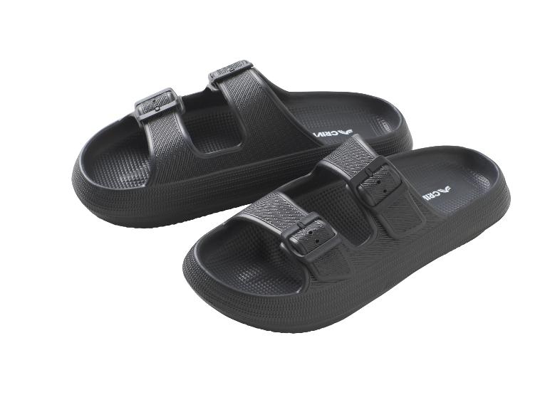 Zwei schwarze Sandalen mit zwei Riemen und Schnallen, auf weißem Hintergrund.