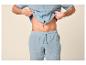 Mann in hellblauem Pyjama, Hemd und Shorts, zeigt seinen Bauch.