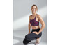 Eine Frau in Sport-BH und Leggings, bereit zum Training.