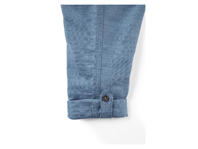 Nahaufnahme eines blauen, gefalteten Ärmels mit einem Knopf.