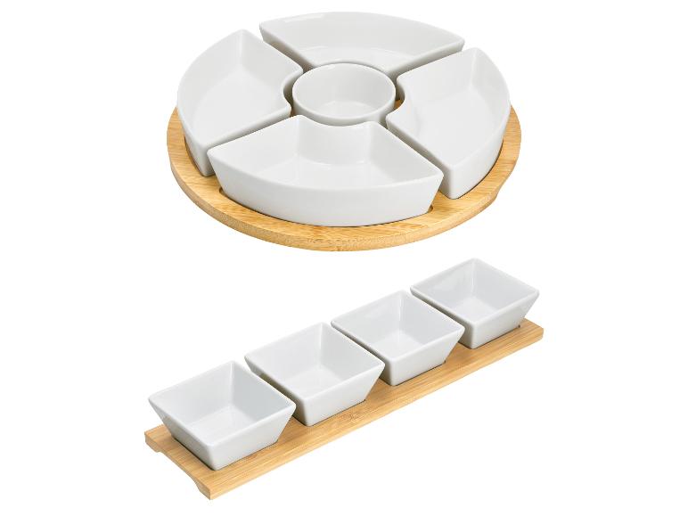 Weiße Porzellan-Snackschalen mit Bambussockel, eine rund und eine rechteckig.