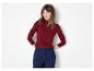 Frau in rotem Rippen-Rollkragenpullover und marineblauer Hose