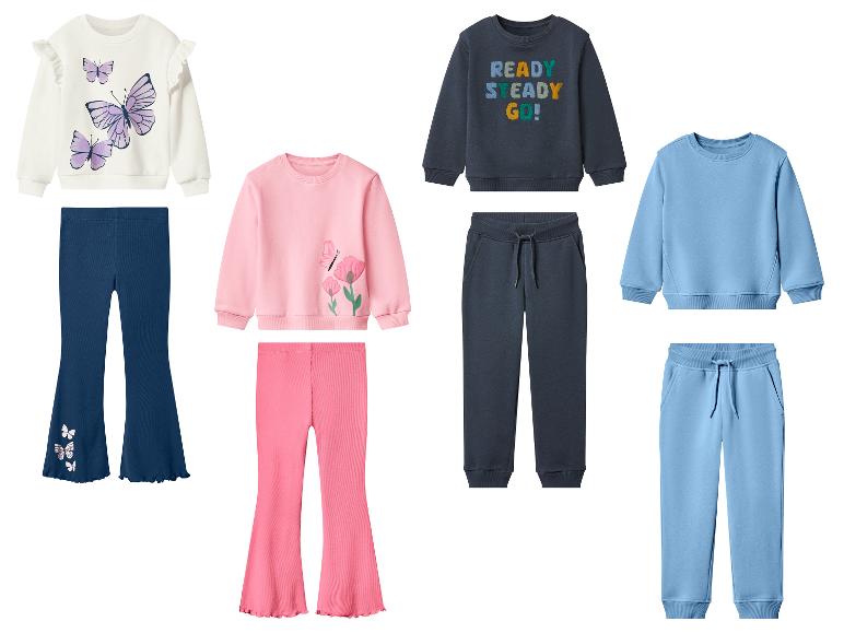 Vier Sets Kinder-Sweatshirts und -Hosen, darunter Schmetterlings- und Blumenmotive sowie der Text „READY STEADY GO!“.