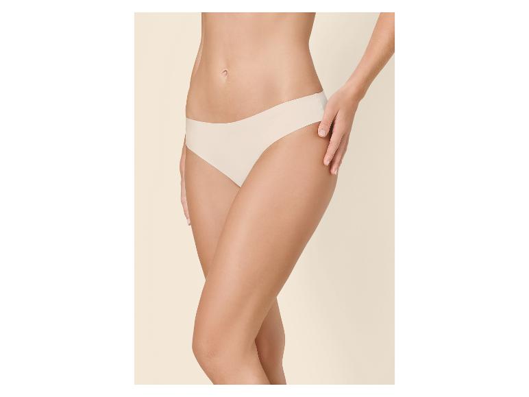 Frau in hautfarbenem Slip, mit einer Hand am Oberschenkel.
