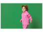 Kleines Mädchen in rosa Regenanzug mit Einhorn-Motiv und dem Text „hello!“